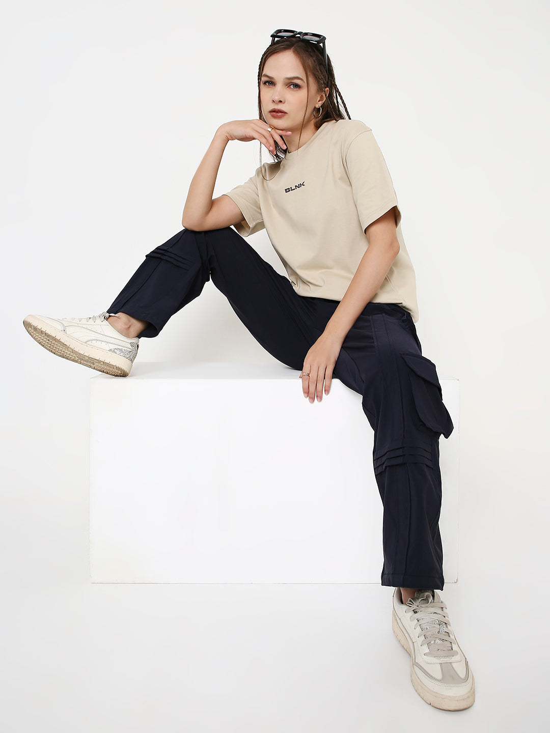 Relaxed fit sand-colored crew neck t-shirt paired with black cargo pants and white sneakers.