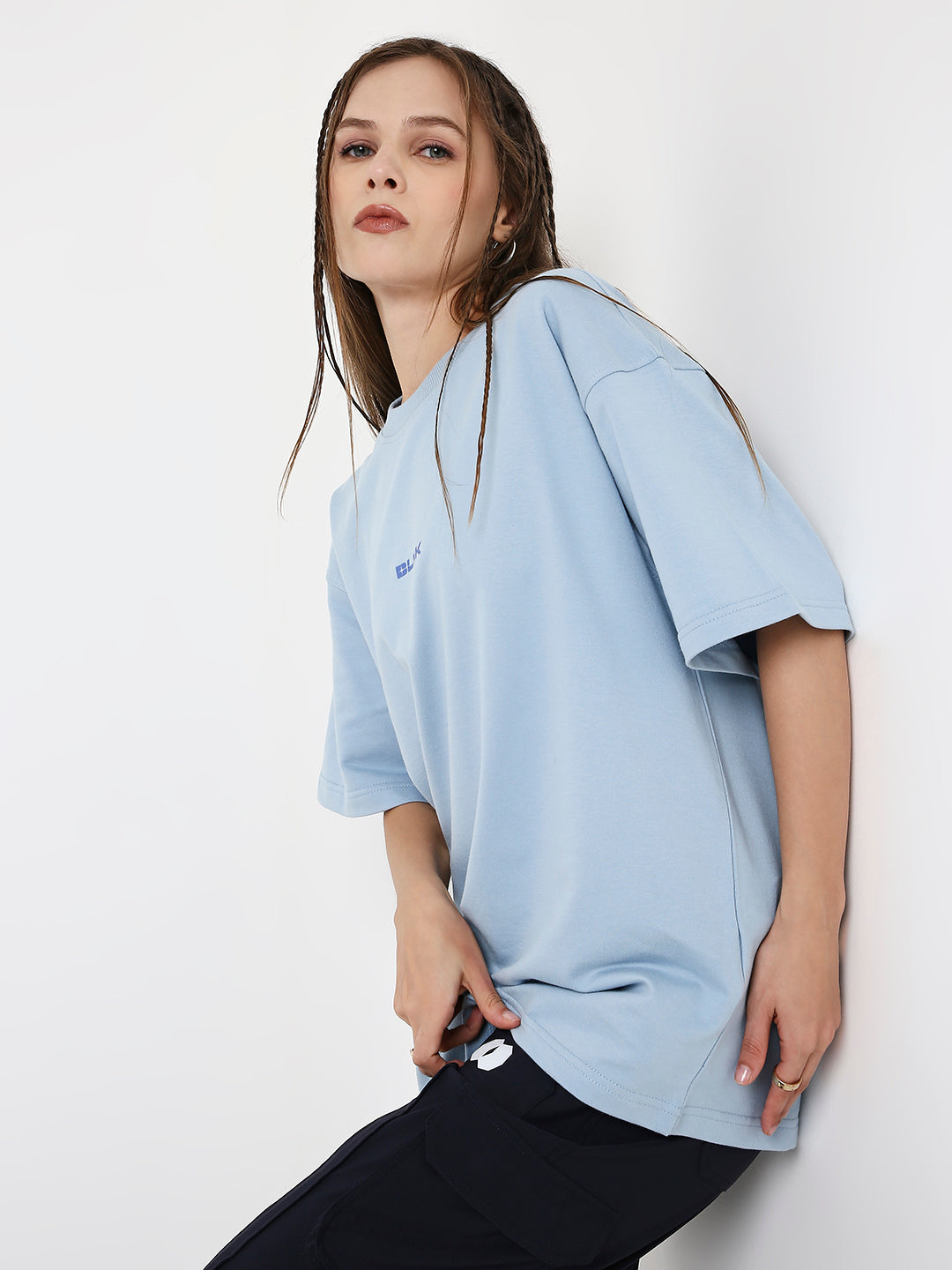 Light blue oversized T-shirt with subtle printed detail, worn loose with short sleeves.