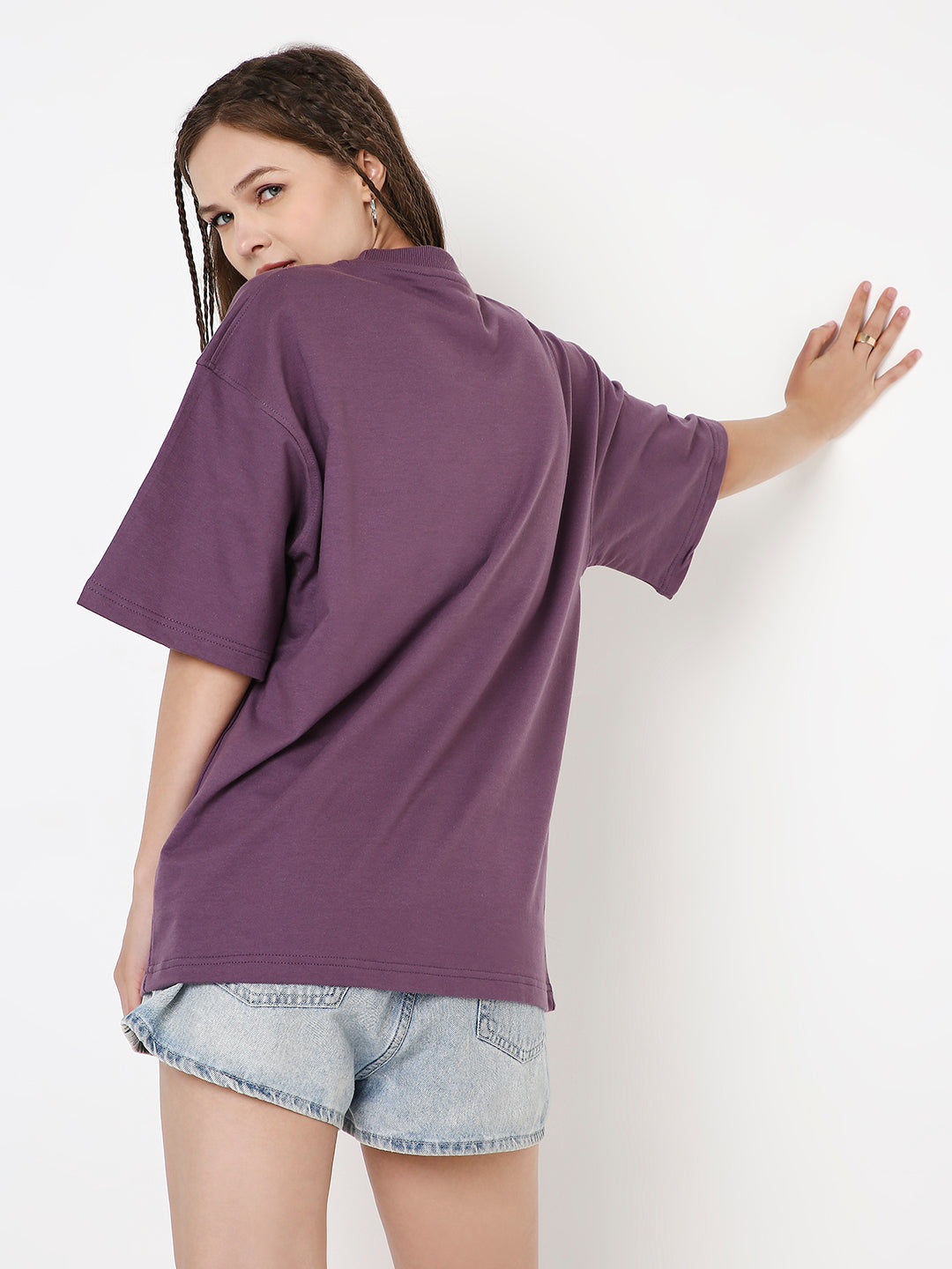 Oversized purple t-shirt with grape print, worn with light denim shorts, back view.
