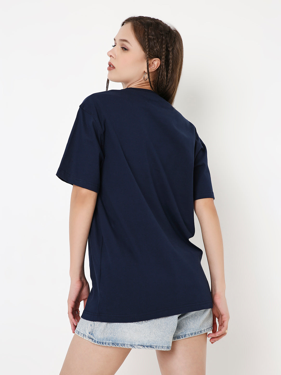 Relaxed fit navy-blue solid T-shirt with short sleeves worn with light denim shorts, shown from the back.