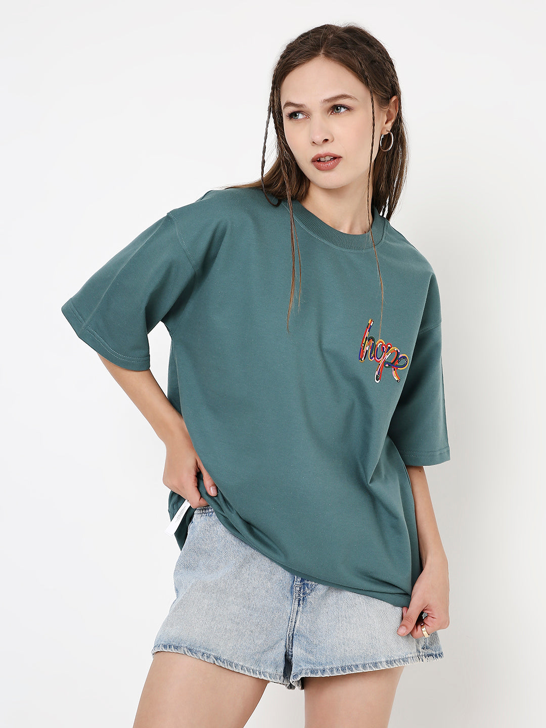 Oversized sapphire-blue t-shirt with colorful butterfly print on chest, paired with light denim shorts.