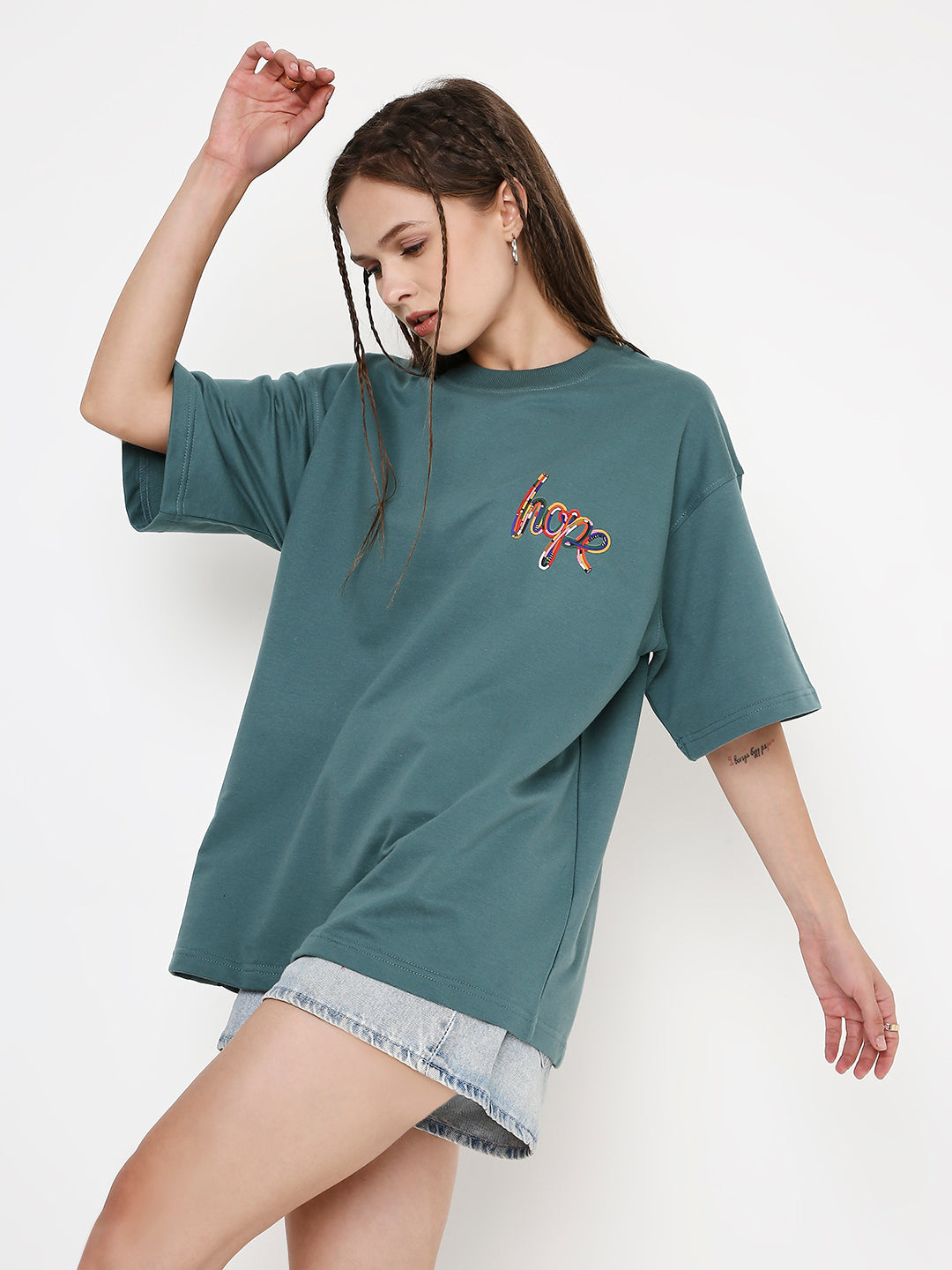 Oversized sapphire-blue t-shirt with colorful abstract print on chest, worn with denim shorts.