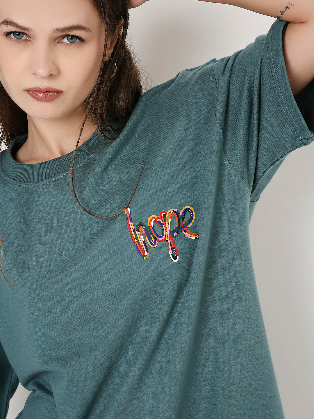 Oversized sapphire-blue T-shirt with colorful embroidered "hope" text on chest.