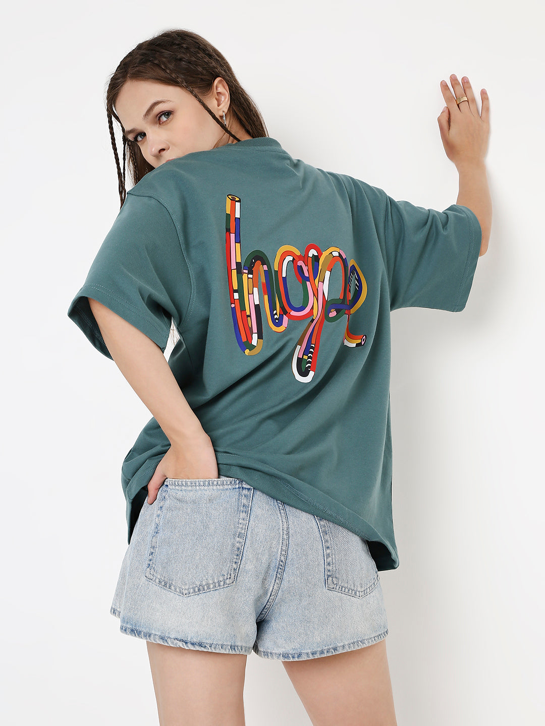 Oversized sapphire-blue t-shirt with colorful "hope" graphic on back, paired with light denim shorts.
