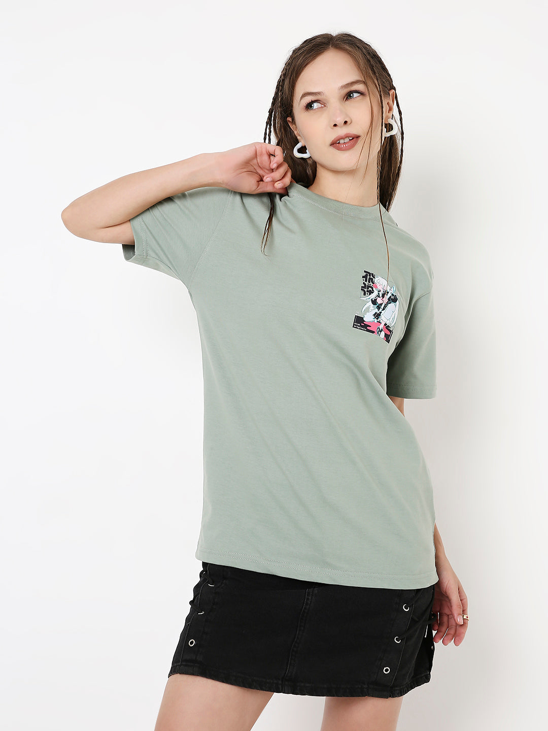 Sage green relaxed fit T-shirt with small graphic print on chest, worn with black skirt.