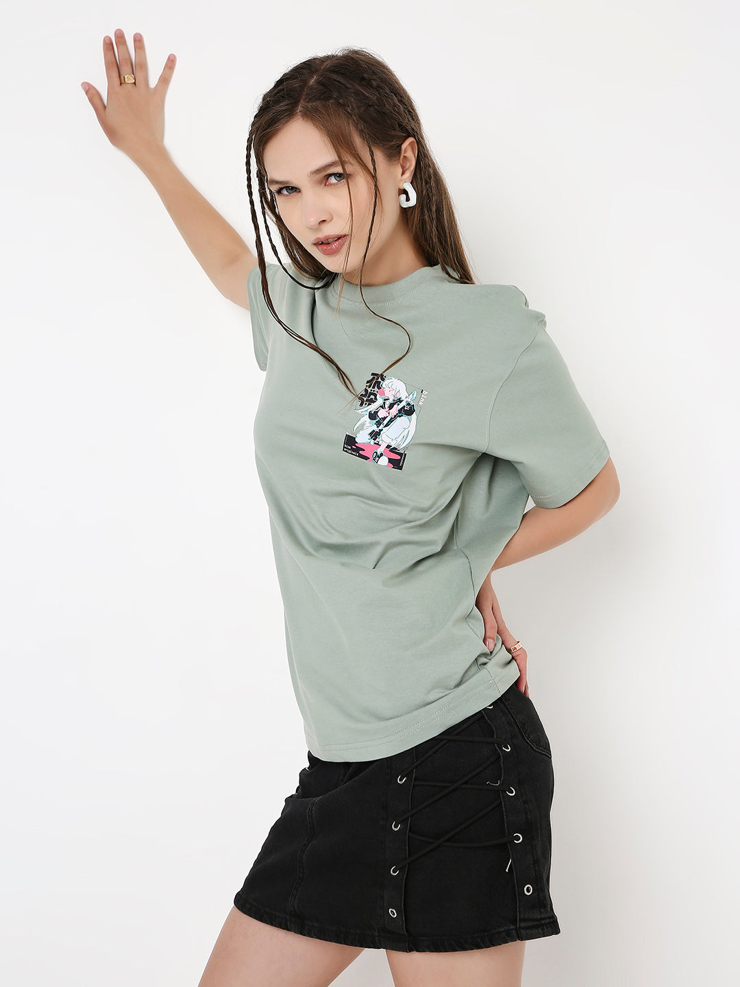 Sage green relaxed fit T-shirt with graphic print on chest, paired with black button-front skirt.