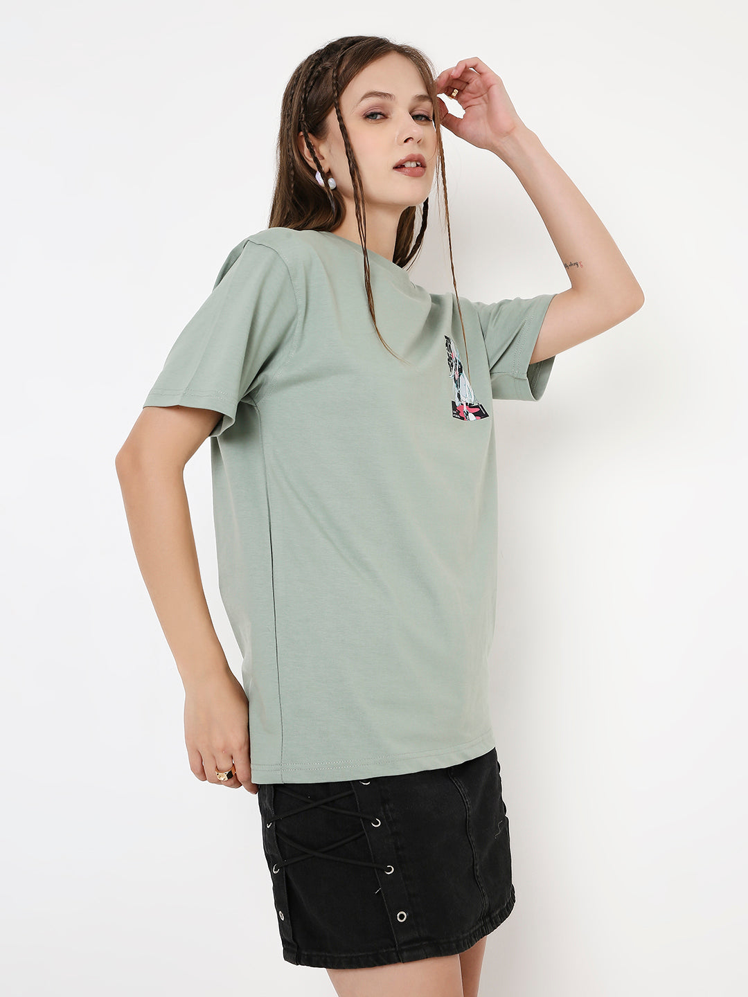 Relaxed fit sage green T-shirt with subtle abstract print, short sleeves, worn with black skirt.