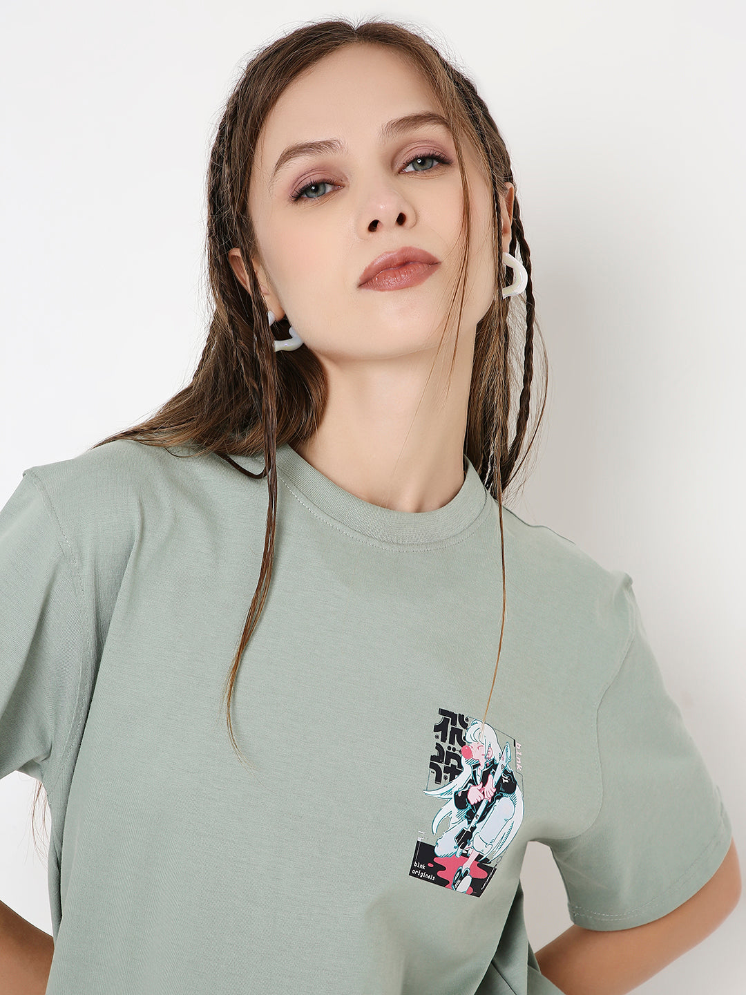 Relaxed fit sage green t-shirt with small floral print on chest pocket, worn by model.