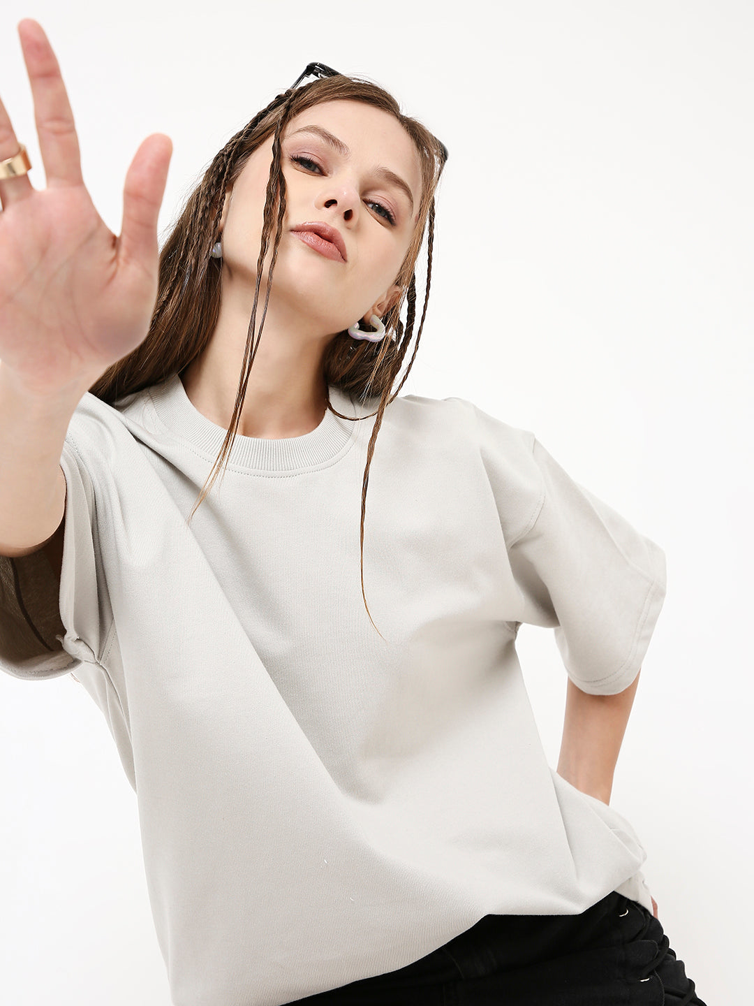 Cream oversized short-sleeve t-shirt with crew neck worn by model with long braided hair.