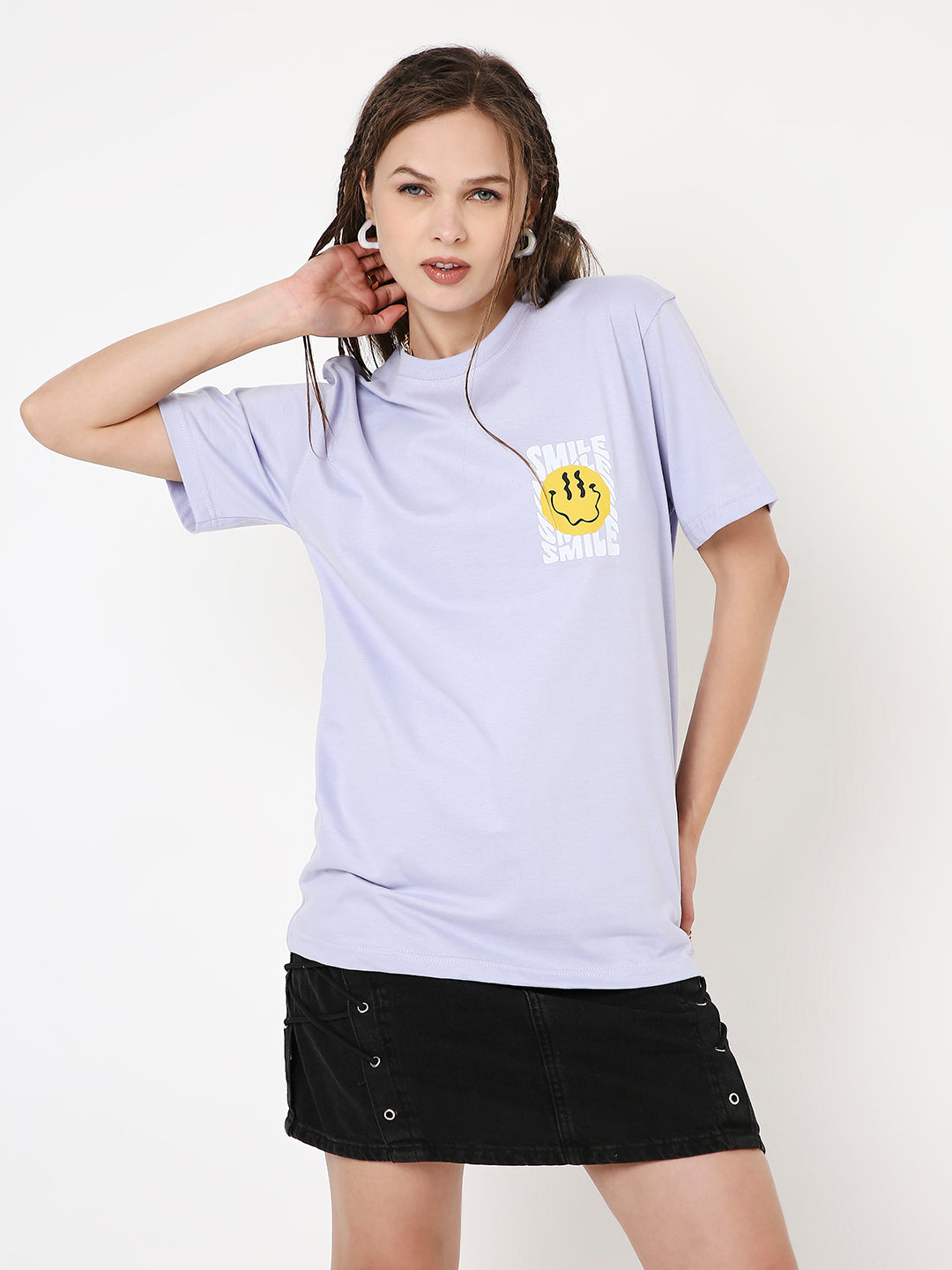 Lavender relaxed fit t-shirt with small yellow smiley face logo on left chest, worn with black skirt.