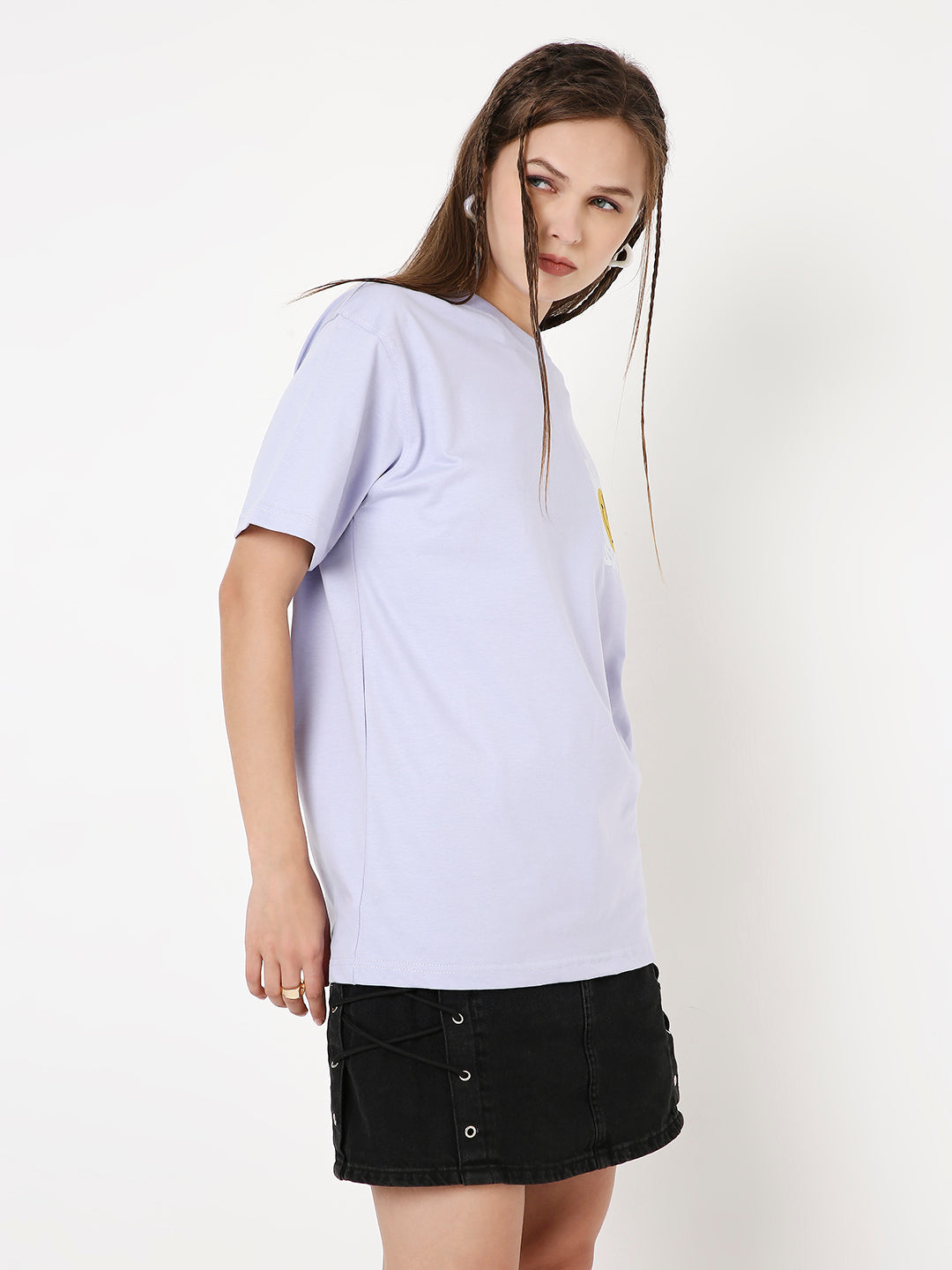 Lavender relaxed fit T-shirt with short sleeves worn with black button-front mini skirt.