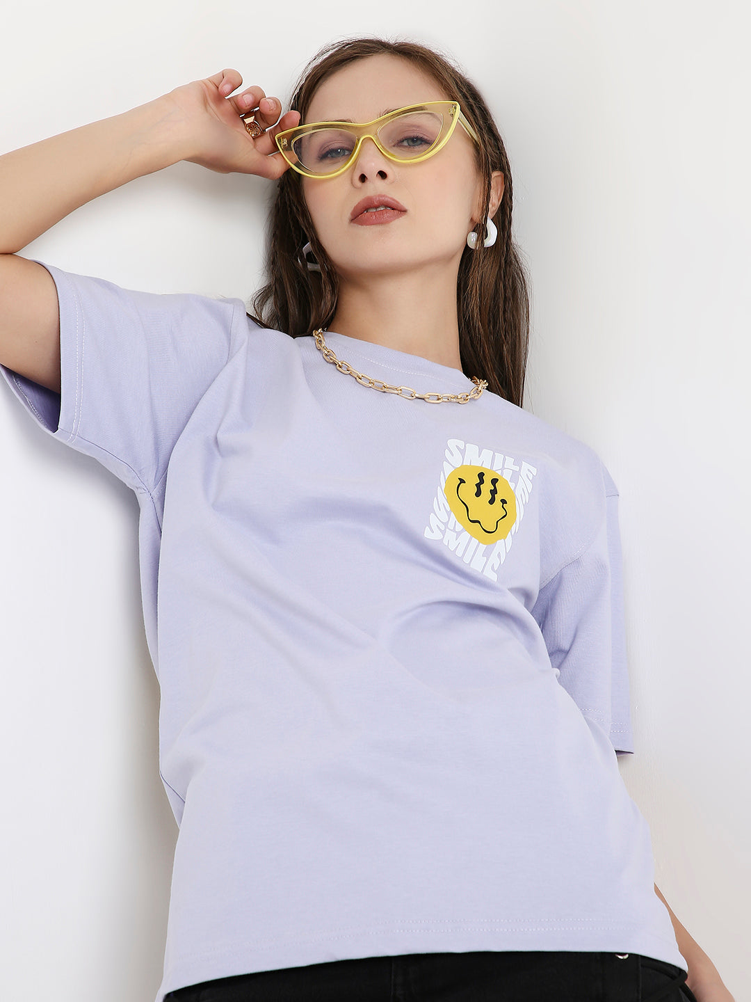 Lavender relaxed-fit T-shirt with yellow smiley face and "Life is good" text on chest, worn with yellow sunglasses.