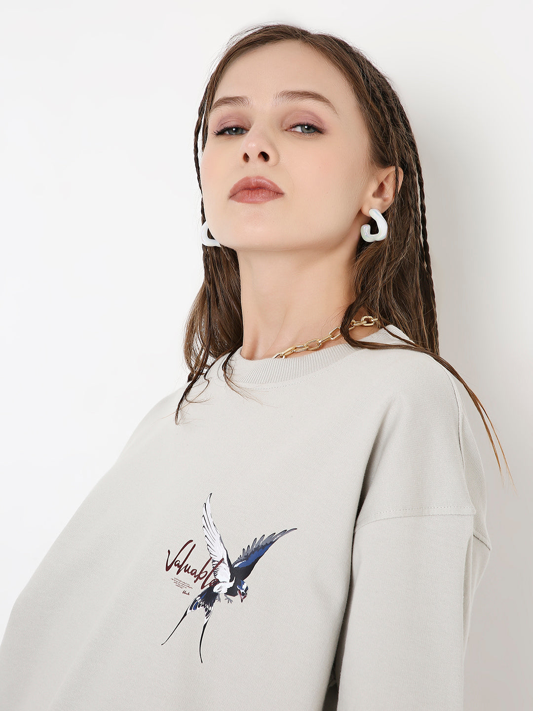 Light gray oversized t-shirt with abstract skipping stone print on left chest and dropped shoulders.