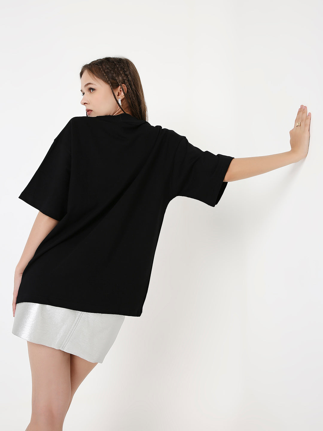 Black oversized short-sleeve T-shirt with a loose fit on a model facing away.