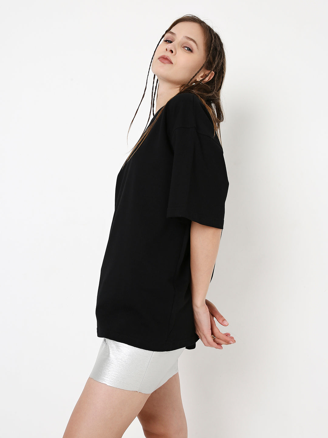 Oversize black T-shirt with short sleeves and relaxed fit worn over silver biker shorts.