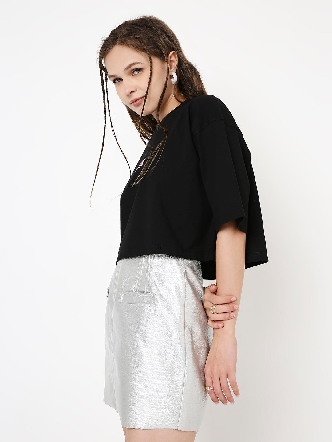 Oversize black crop top with wide sleeves and subtle front print worn with silver skirt.