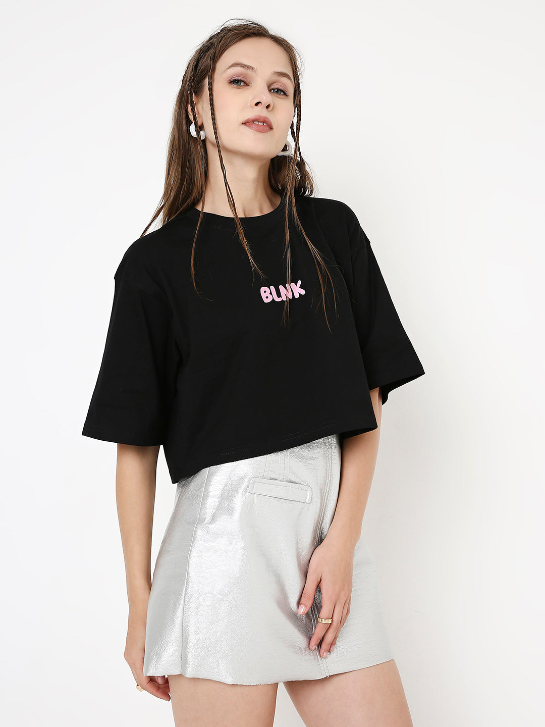 Oversize black crop top with pink BLINK print, paired with a white high-waisted skirt.