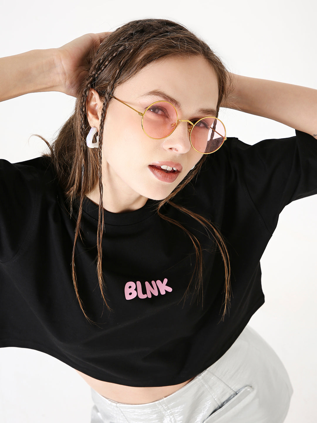 Black oversized crop top with pink "BLINK" print, paired with light-colored pants.
