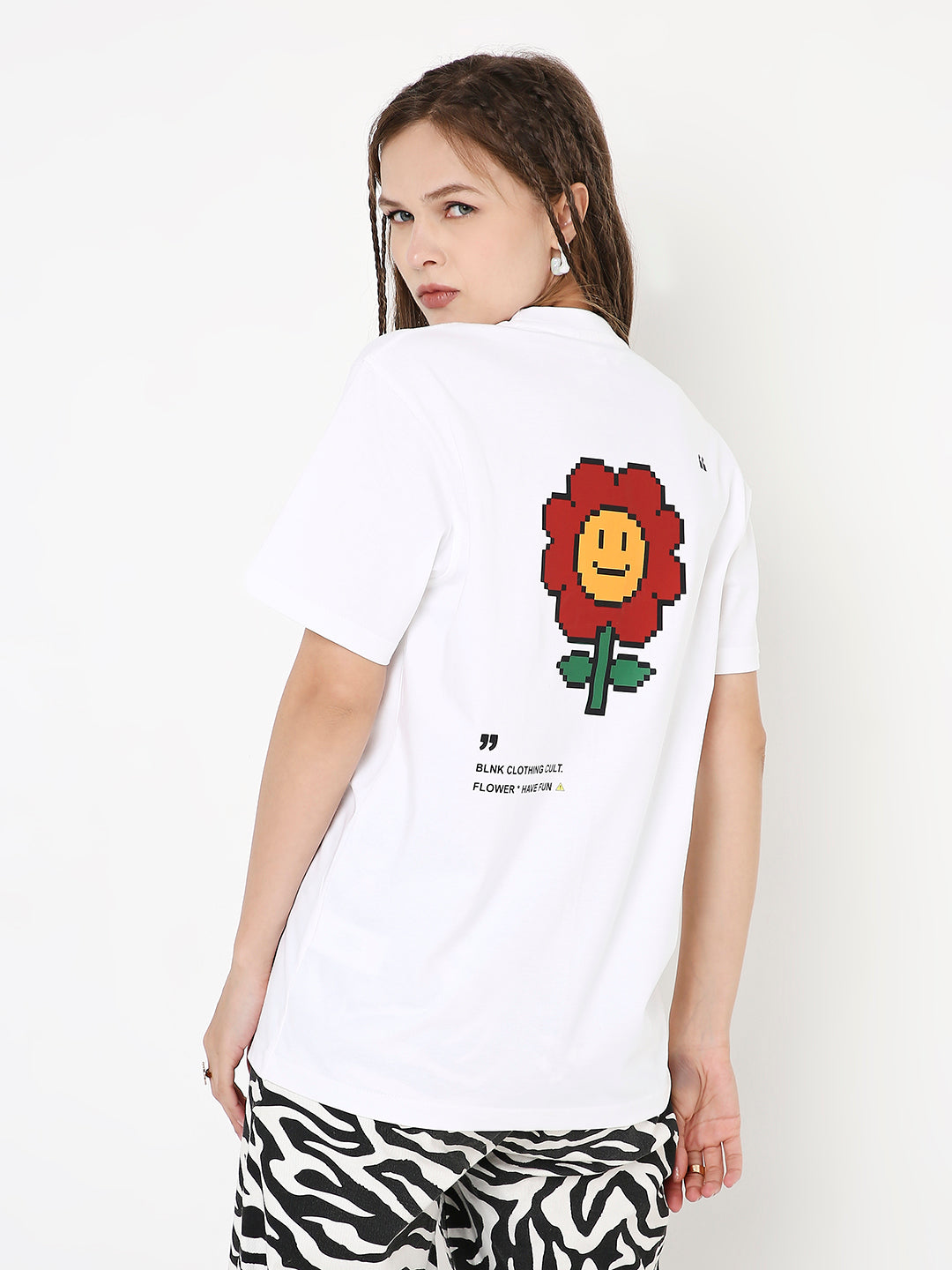 White relaxed fit t-shirt with a red smiling flower graphic on the back.
