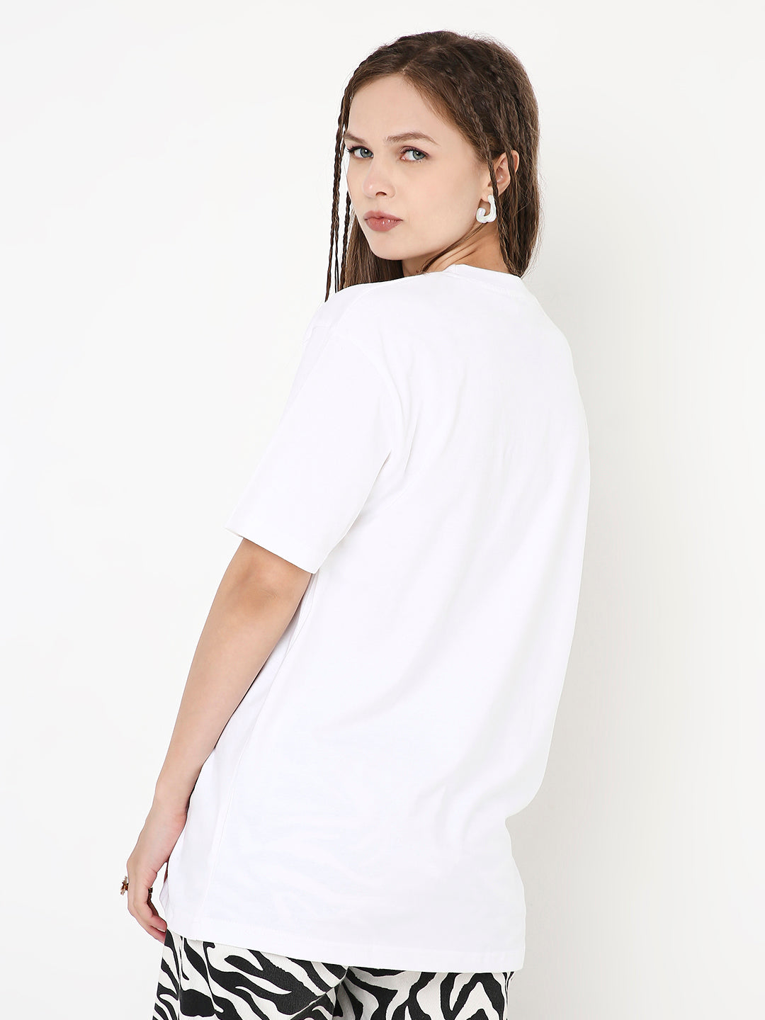 Relaxed fit white solid t-shirt with short sleeves on a model facing backward.