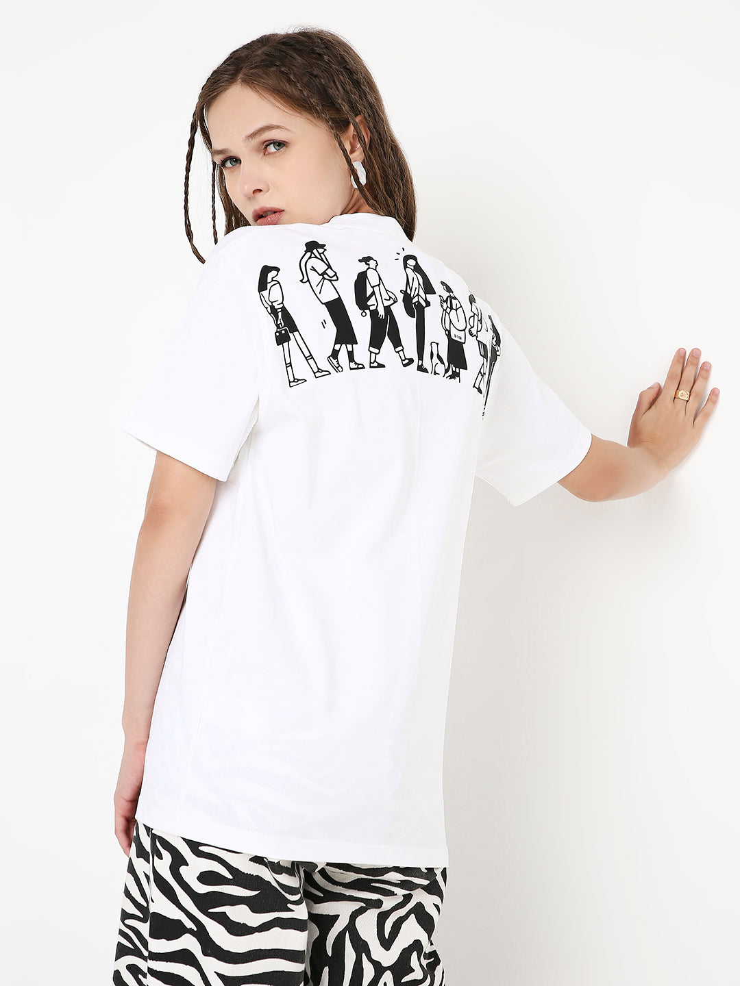 White relaxed fit t-shirt with black graphic print of multiple women on the back, paired with zebra print pants.