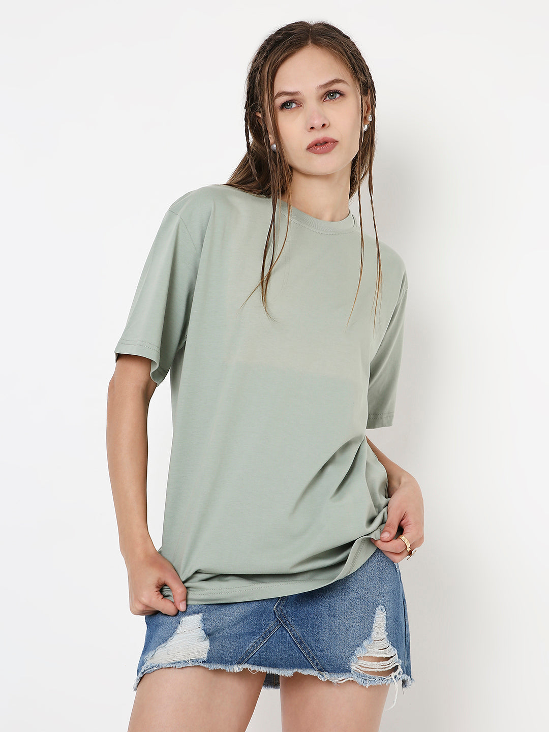 Relaxed fit sage green short-sleeve t-shirt worn with distressed denim mini skirt.