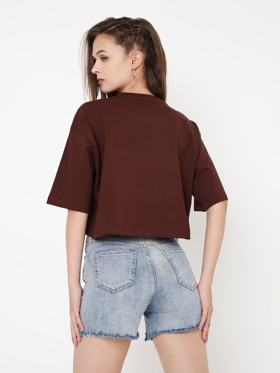 Oversize brown crop top with short sleeves and a boxy fit paired with light blue denim shorts.