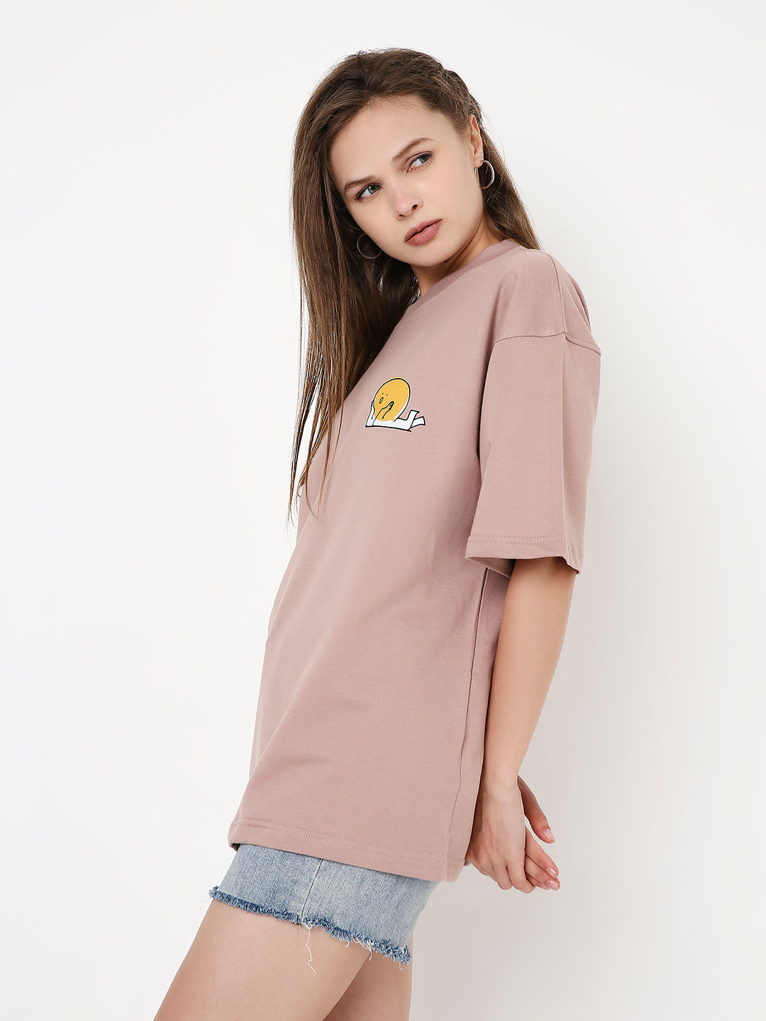 Oversize onion pink t-shirt with small yellow onion graphic on chest, worn with denim shorts.