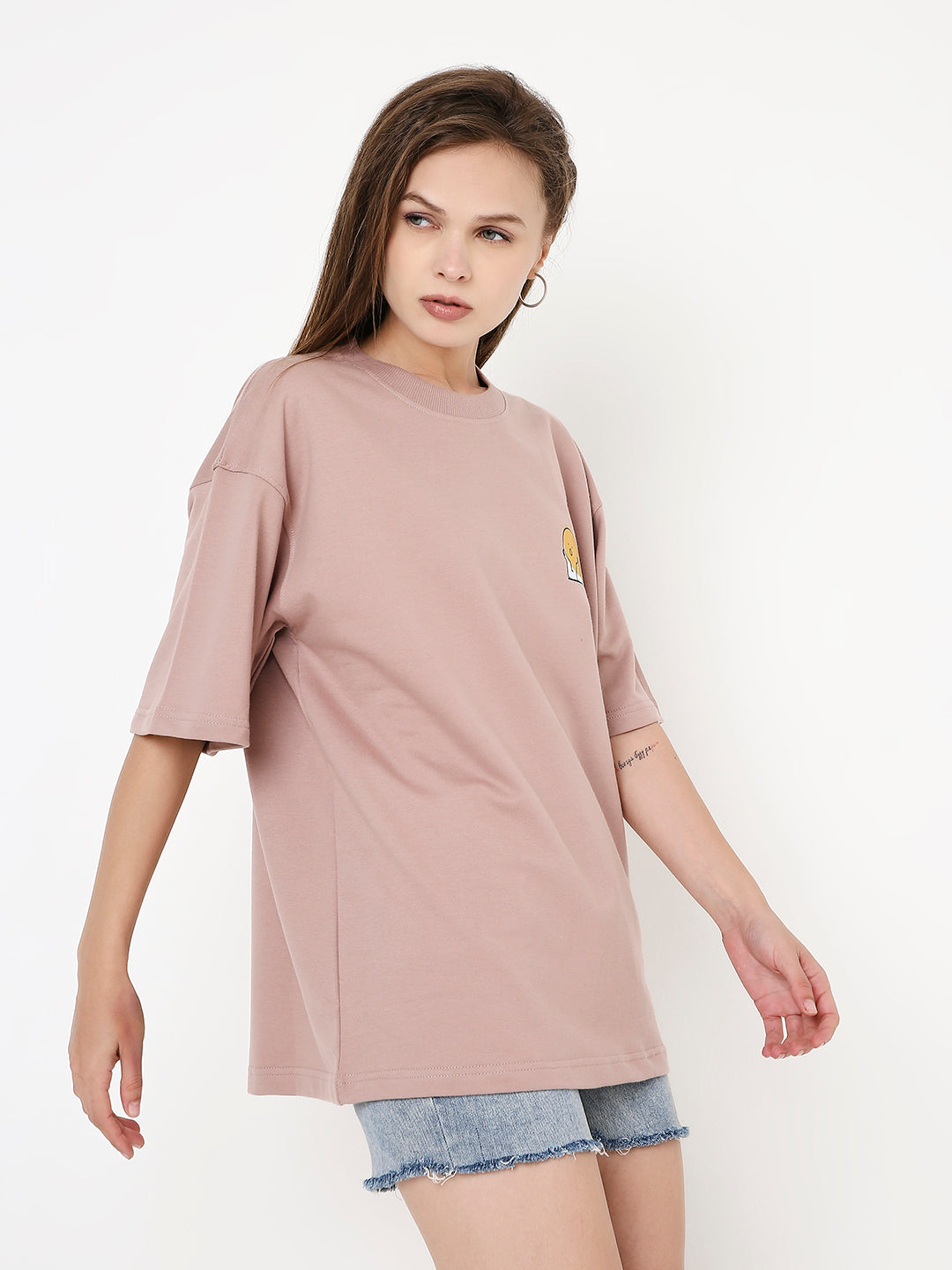 Oversize onion pink T-shirt with round neck and short sleeves, worn with denim shorts.
