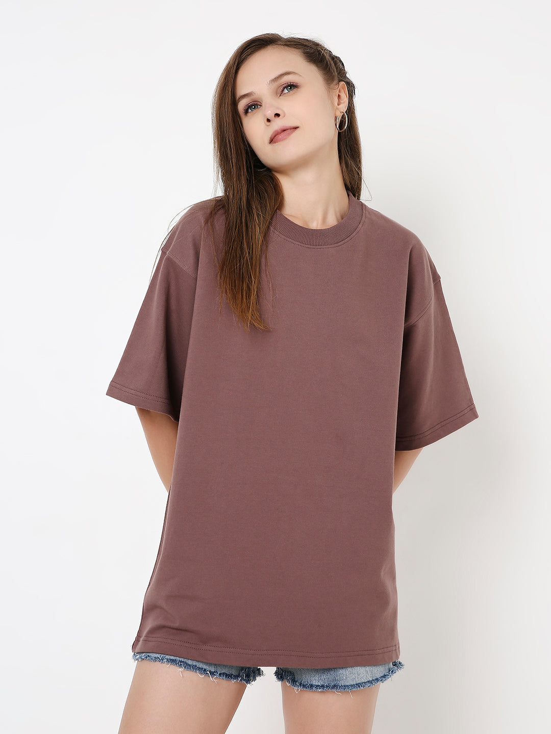 Oversize old rose solid t-shirt with short sleeves and crew neckline, worn with denim shorts.