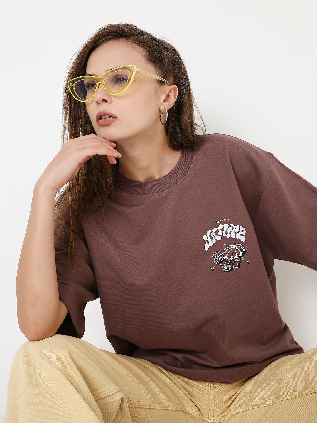 Oversize old rose printed t-shirt with white graphic and brown bear detail, worn with beige pants.