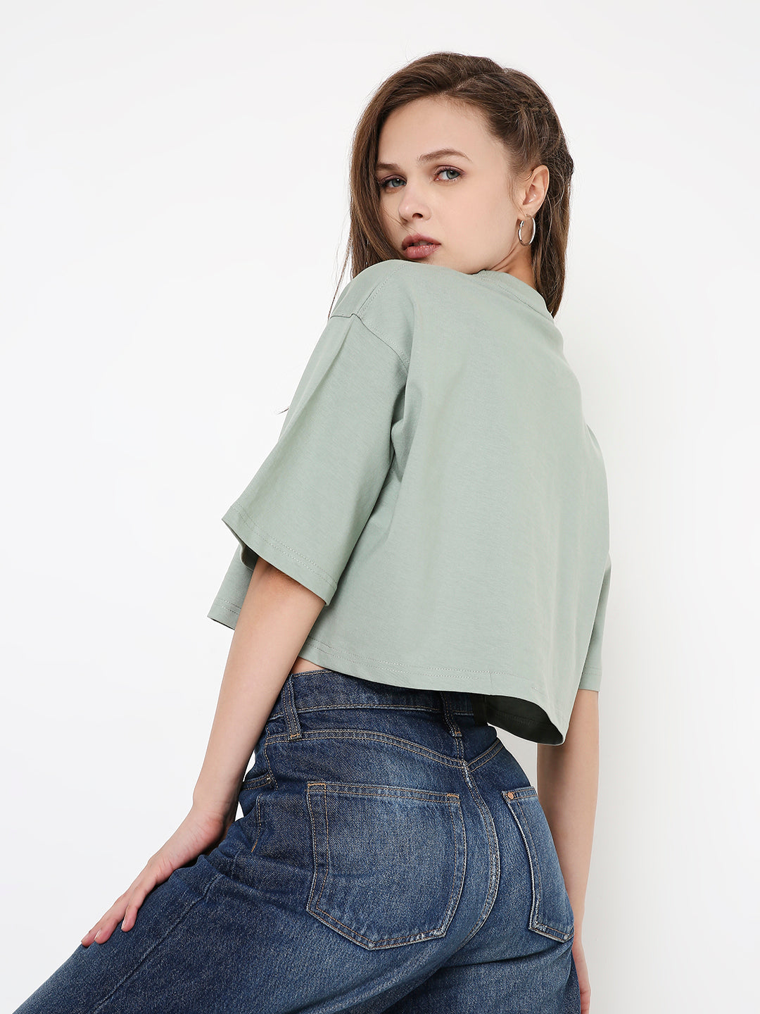 Oversize sage green crop top with dropped shoulders and loose fit on model.