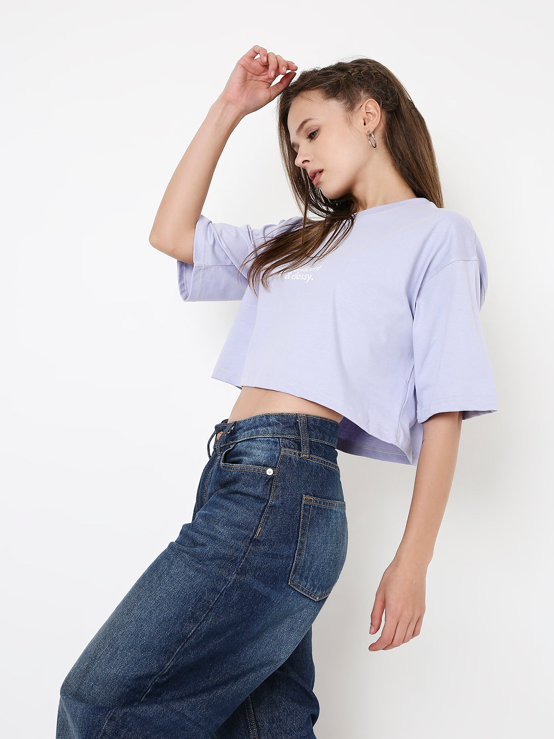Lavender oversized crop top with wide sleeves paired with dark blue high-waisted jeans.