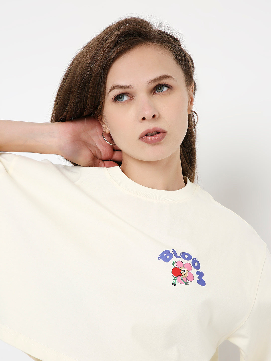 Off-white oversized crop top with colorful graphic print and wide sleeves.