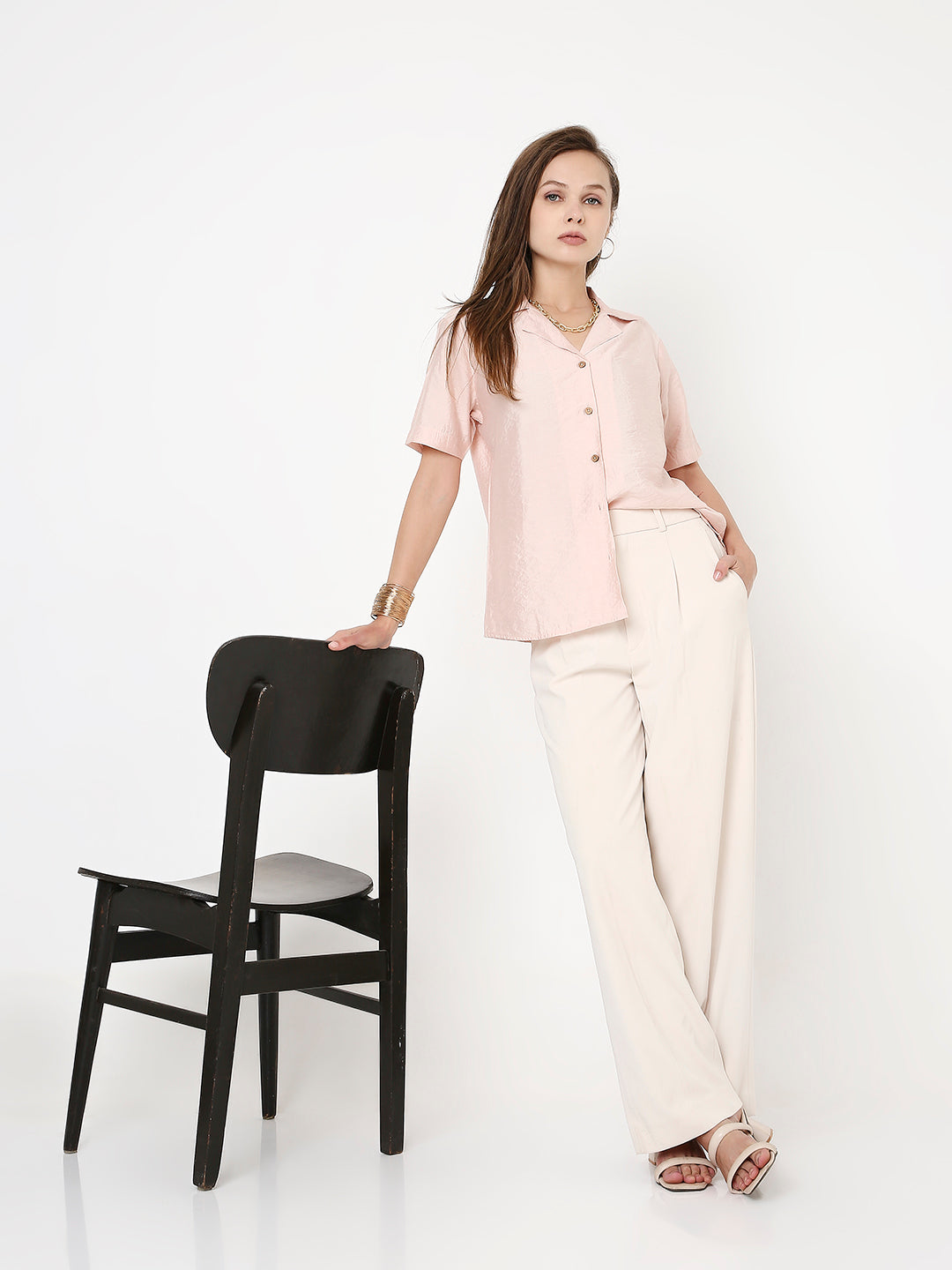 Peach short-sleeve shirt with collar and buttons, paired with white wide-leg pants.