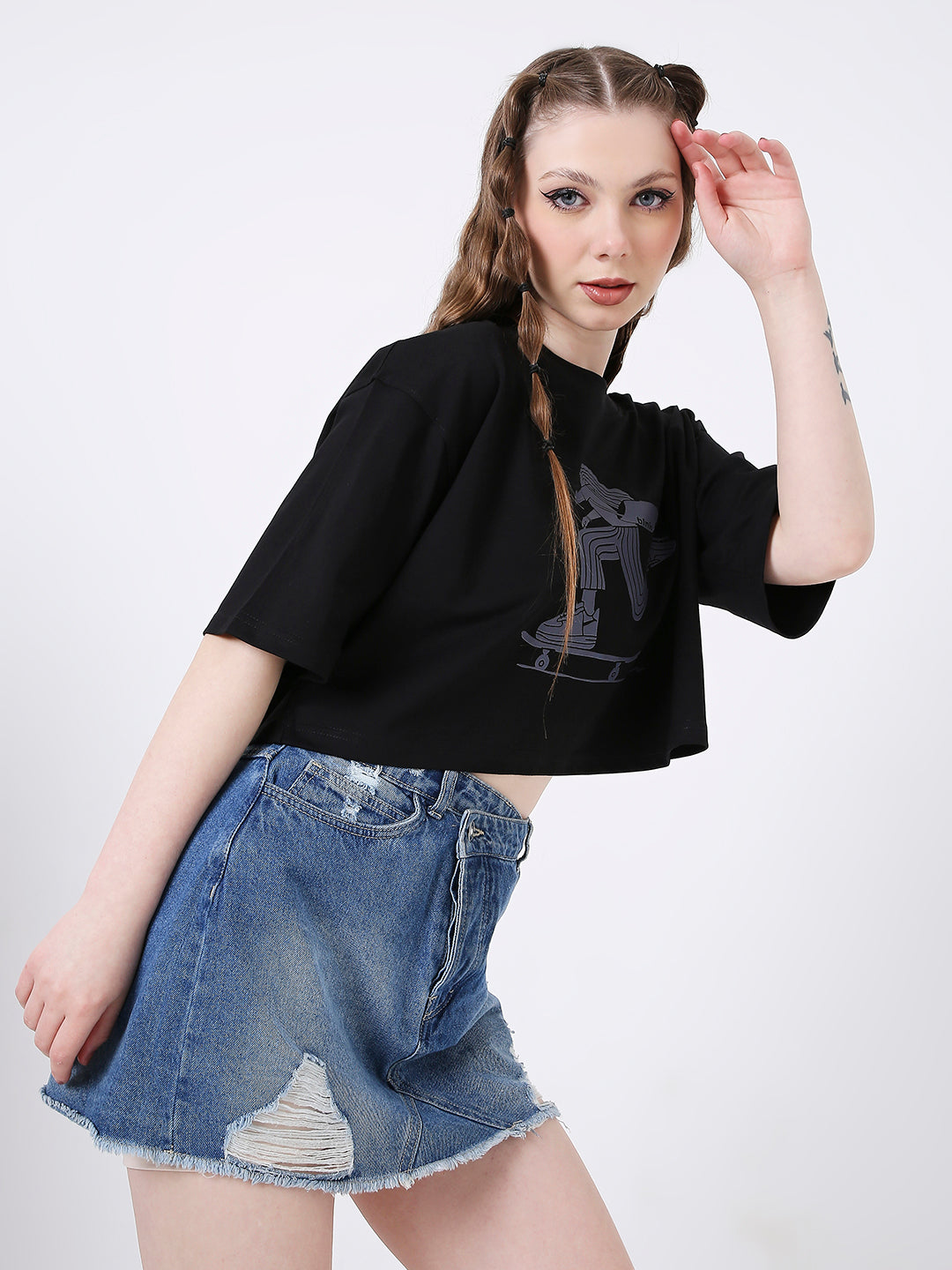Black oversized crop top with abstract gray print, paired with distressed high-waisted denim skirt.