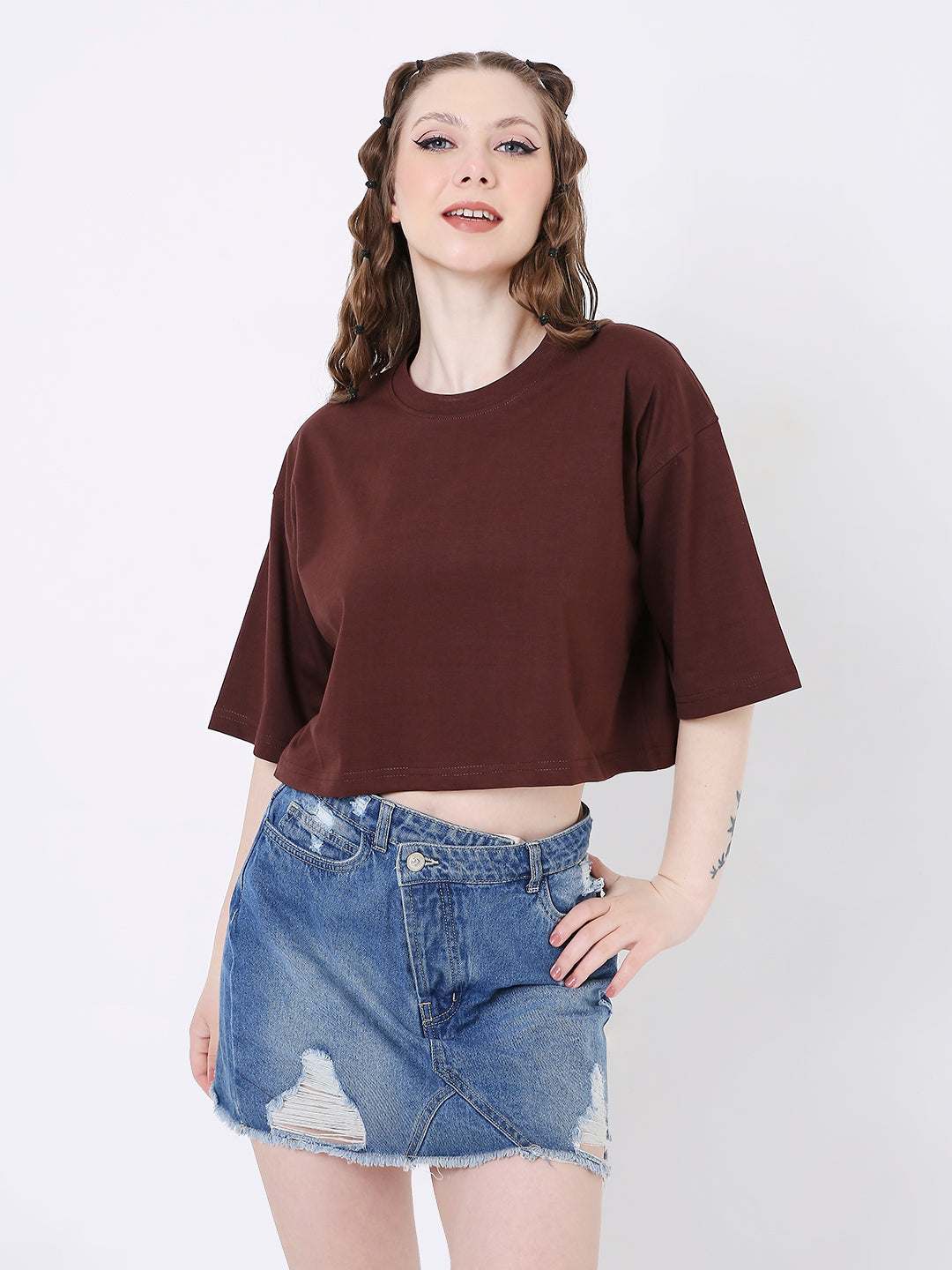 Oversize brown solid crop top with wide elbow-length sleeves, worn with distressed denim skirt.
