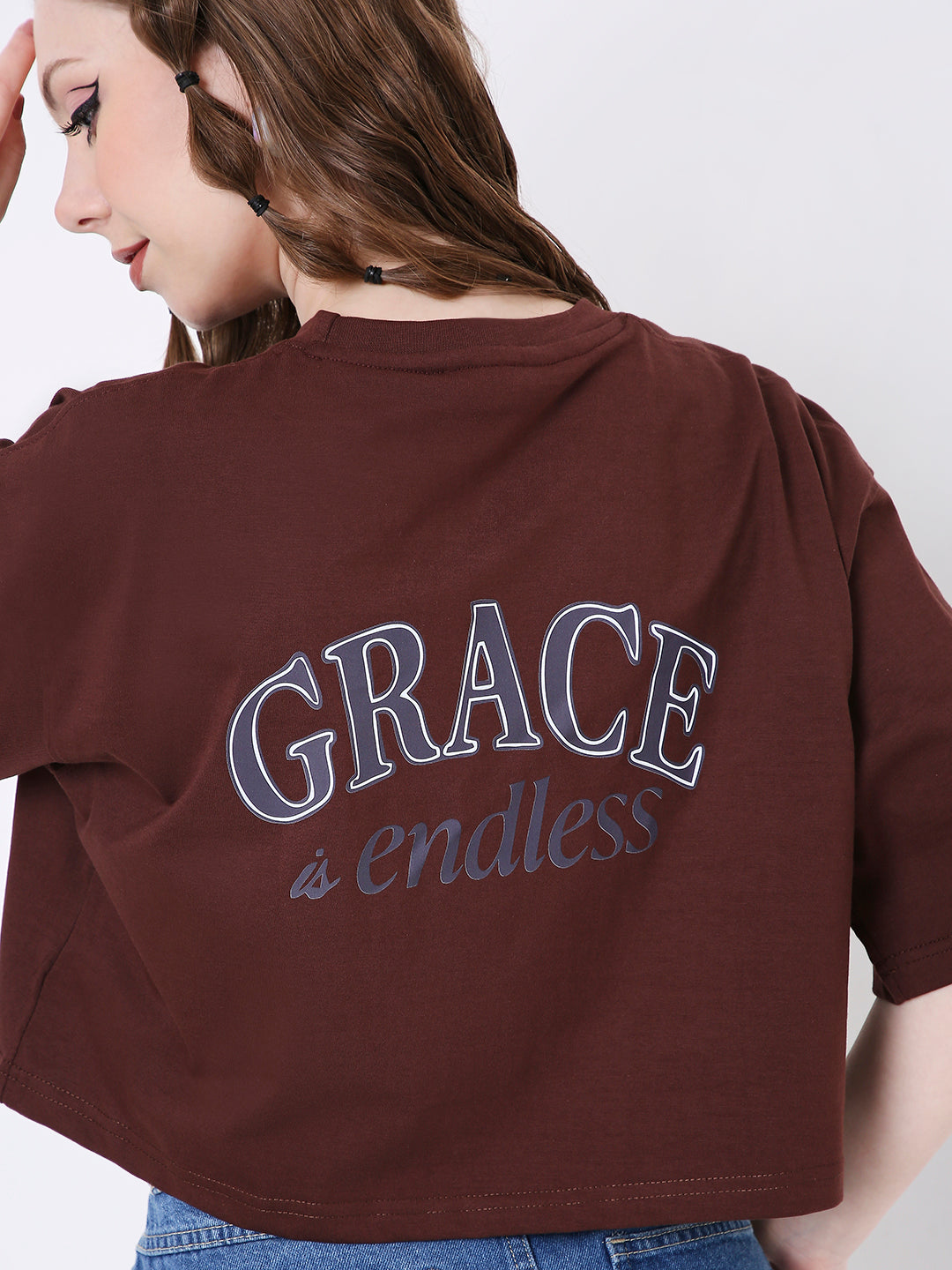 Oversize brown crop top with blue "GRACE is endless" printed text on back.