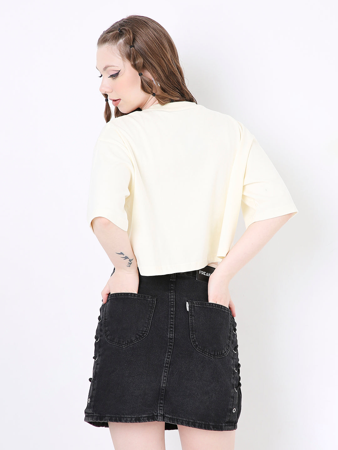 Off-white oversized solid cropped top with elbow-length sleeves worn with black high-waisted skirt.
