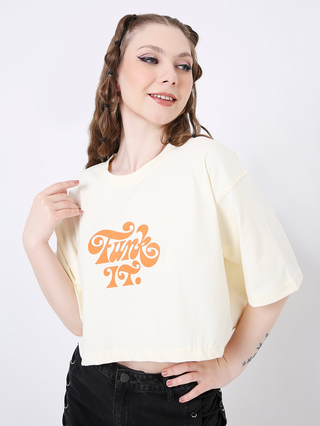 Off-white oversized crop top with orange retro-style print and short sleeves.