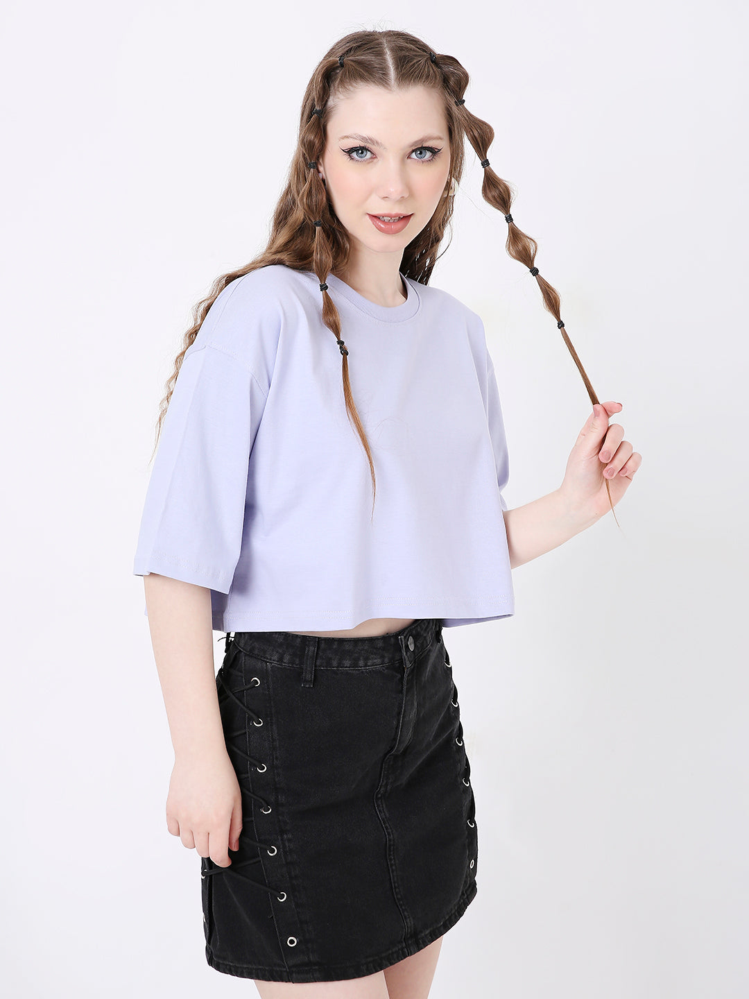 Oversize lavender crop top with short sleeves and round neckline paired with black denim skirt.