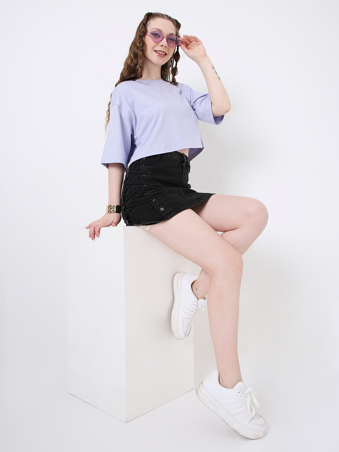 Oversize lavender cropped top with elbow-length sleeves paired with black high-waisted shorts and white sneakers.