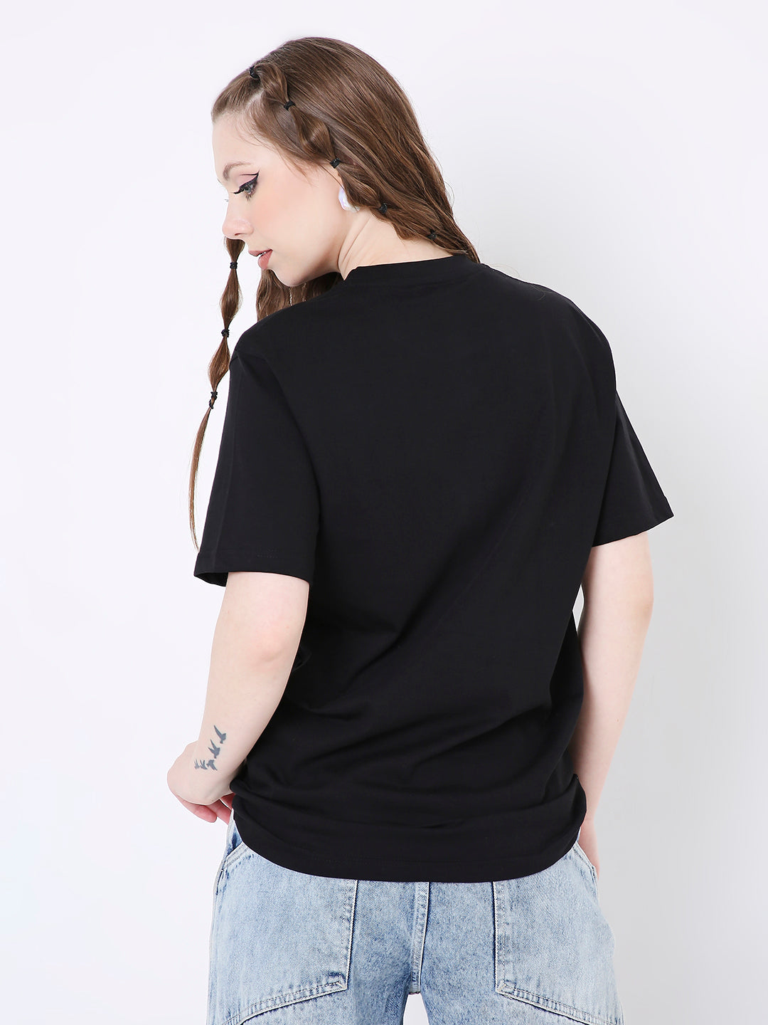 Relaxed fit black cotton t-shirt with short sleeves, worn untucked with light blue denim jeans, shown from the back.