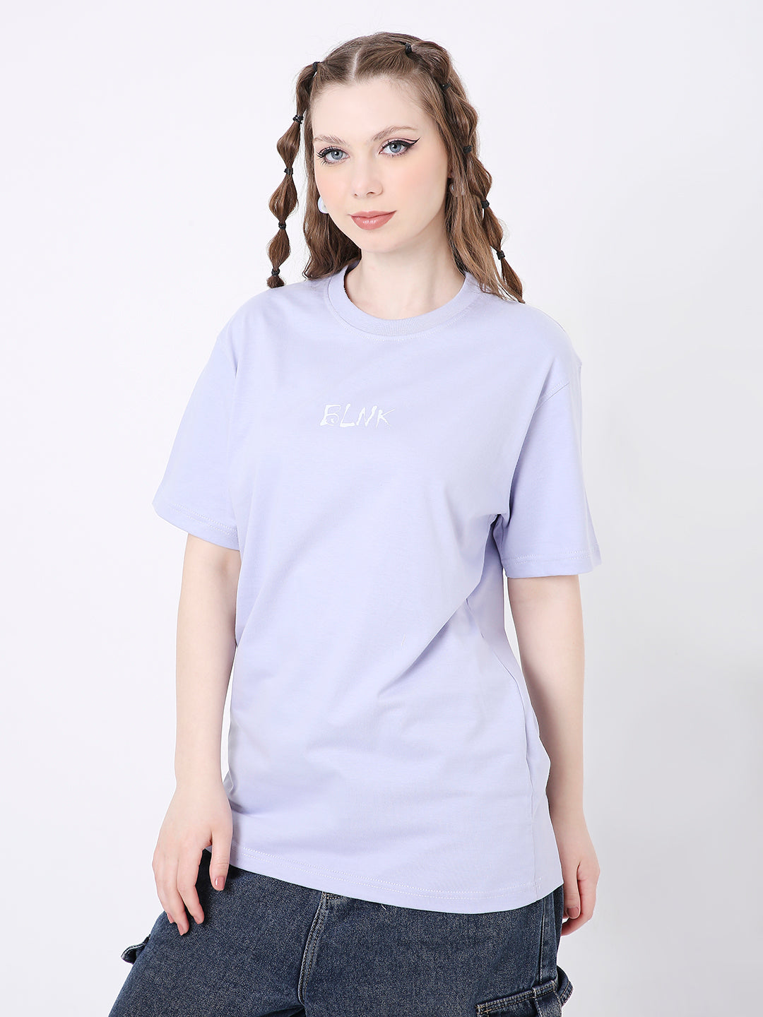 Lavender relaxed fit t-shirt with subtle white printed text on chest, worn with dark denim skirt.