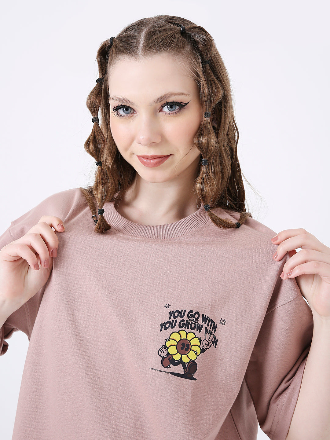 Oversize onion pink t-shirt with yellow flower and black text print on chest.