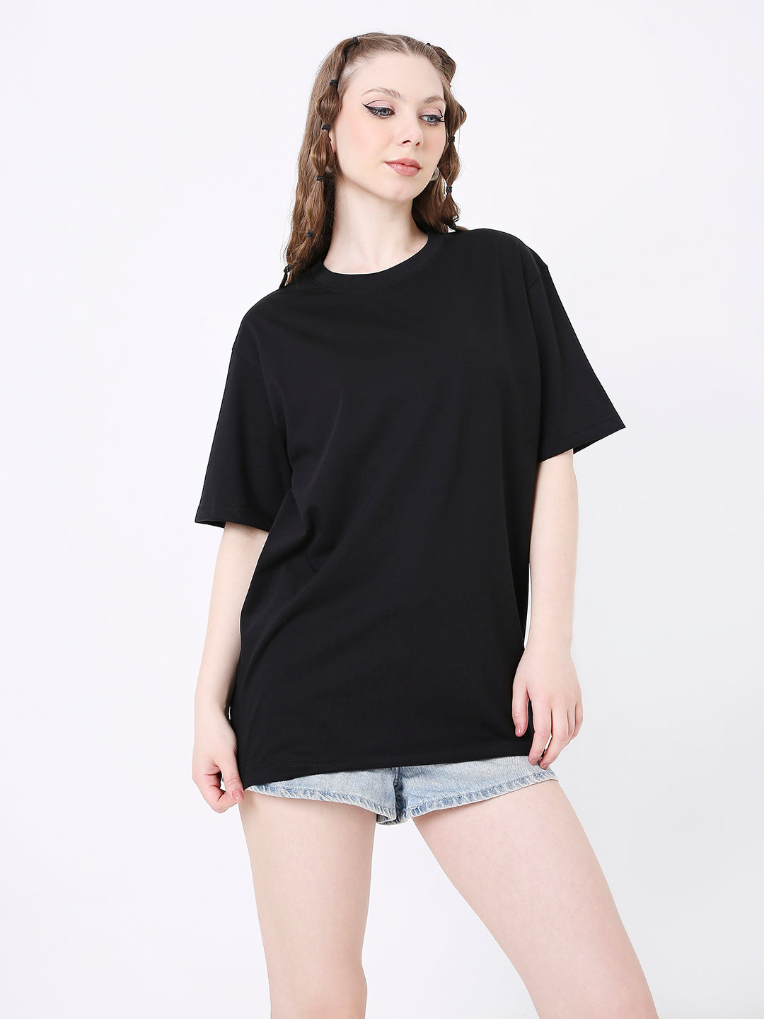 Relaxed fit black solid t-shirt with crew neck and short sleeves worn with light denim shorts.