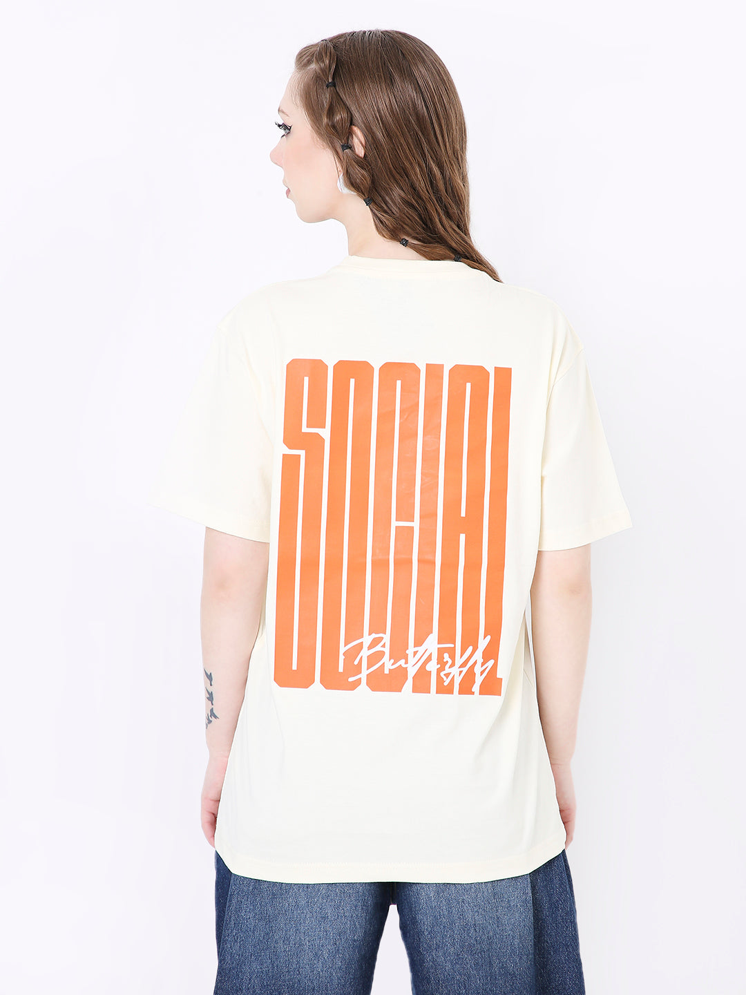 Off-white relaxed fit t-shirt with oversized orange "SOCIAL" print on the back and subtle splatter details.