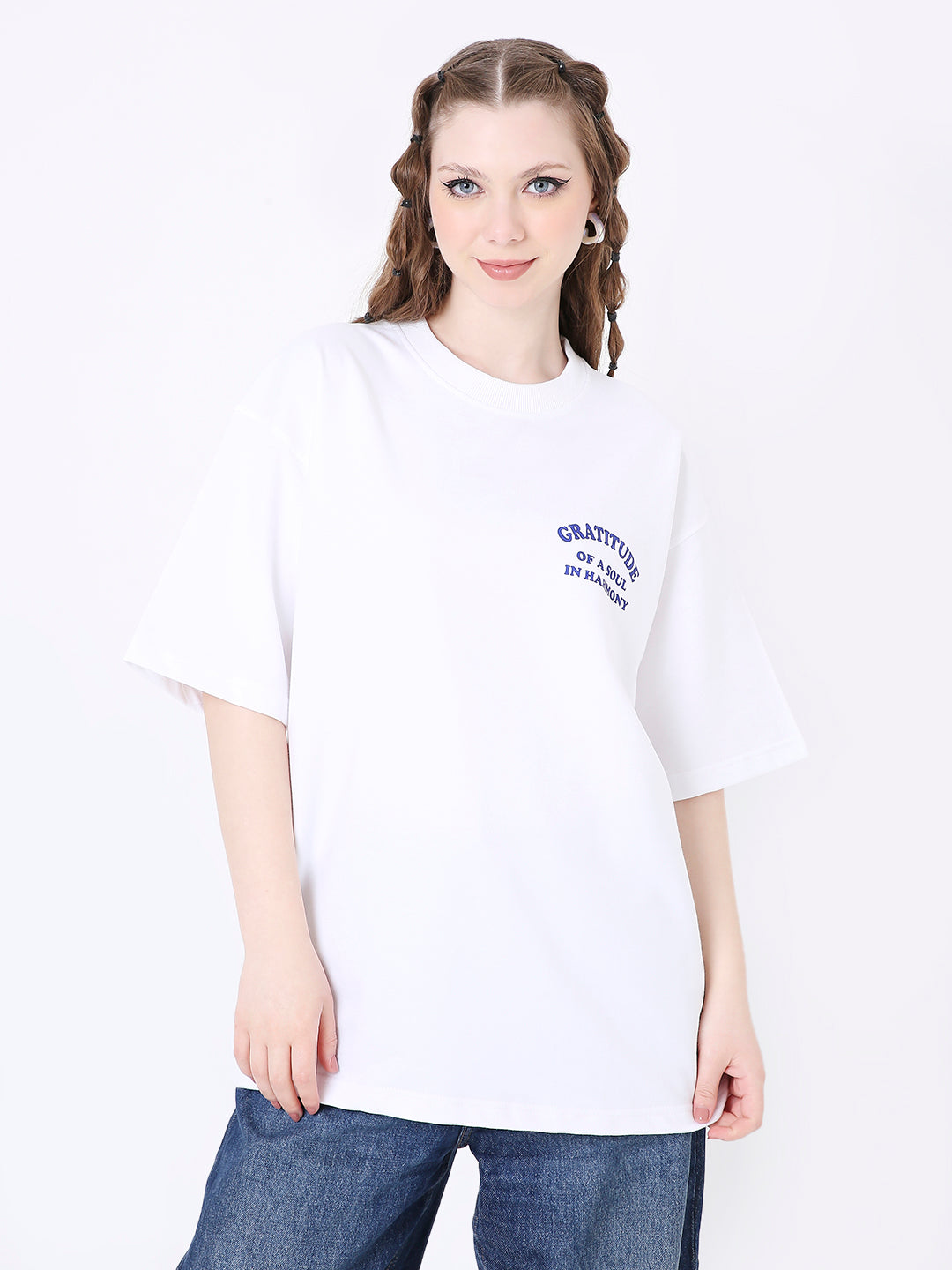 Oversize white t-shirt with small navy text print on left chest, paired with blue jeans.