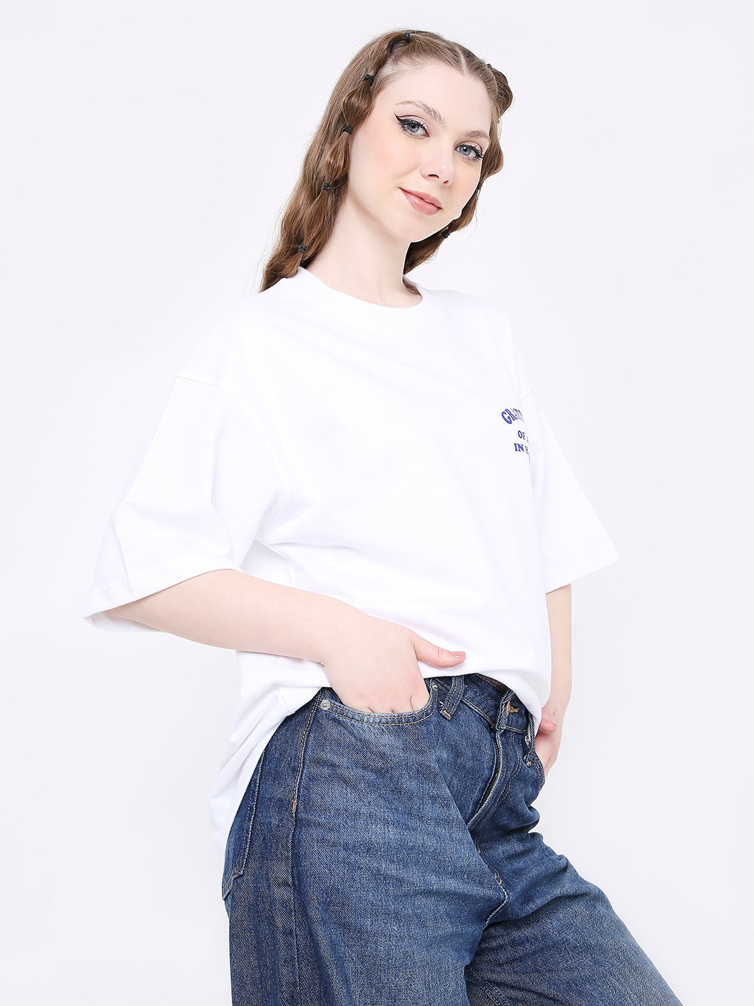 Oversized white t-shirt with small printed detail on chest, paired with blue jeans.