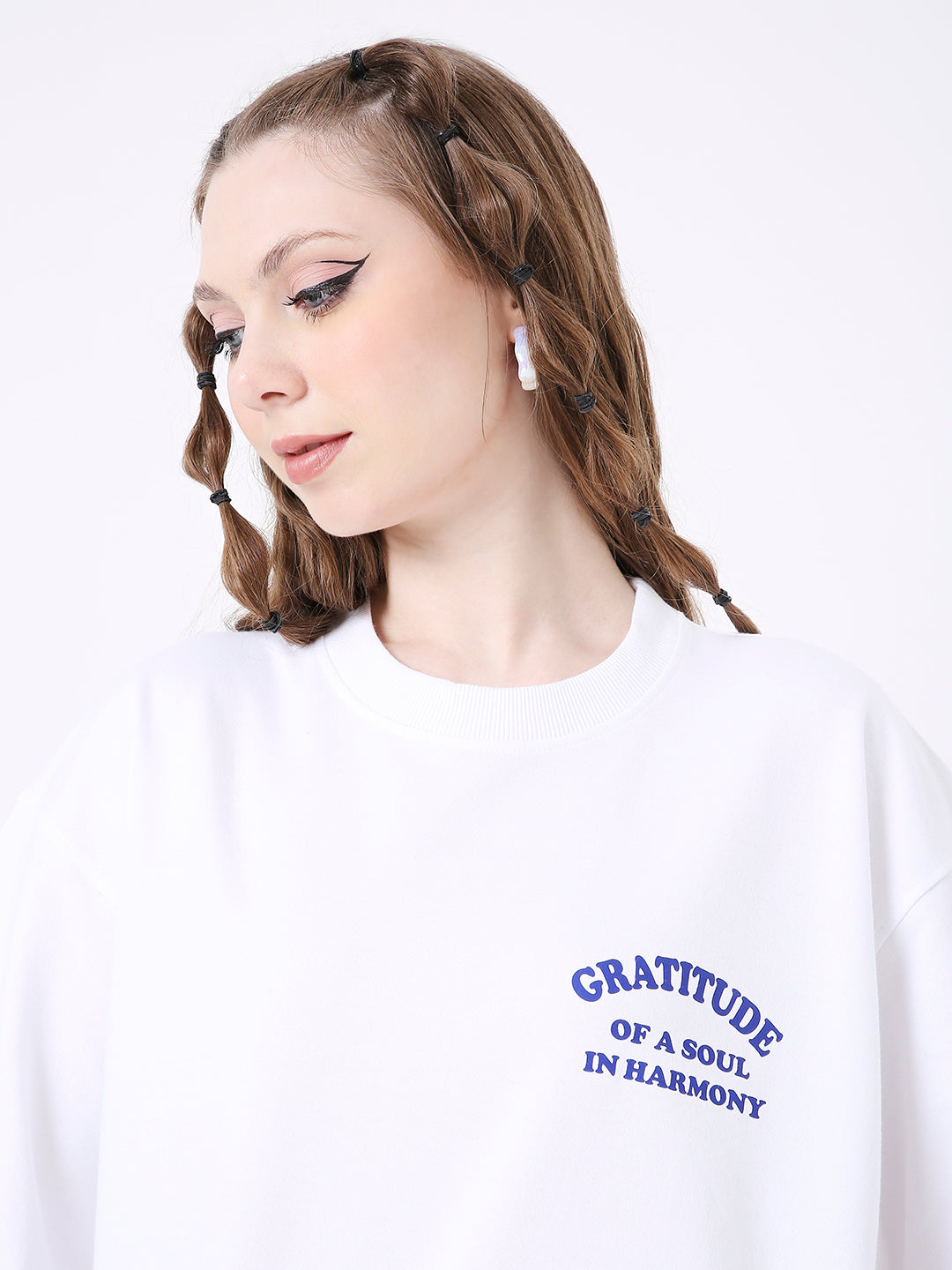 Oversize white T-shirt with blue "Gratitude of a Soul in Harmony" print on chest, worn by woman with braided hair.